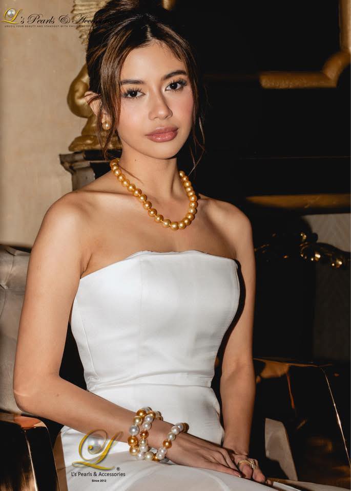 Woman in a white dress with gold jewelry in an elegant setting